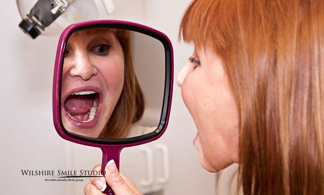 woman checking teeth in mirror woman checking teeth in mirror