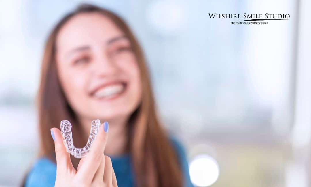 woman holding invisalign tray woman holding invisalign tray